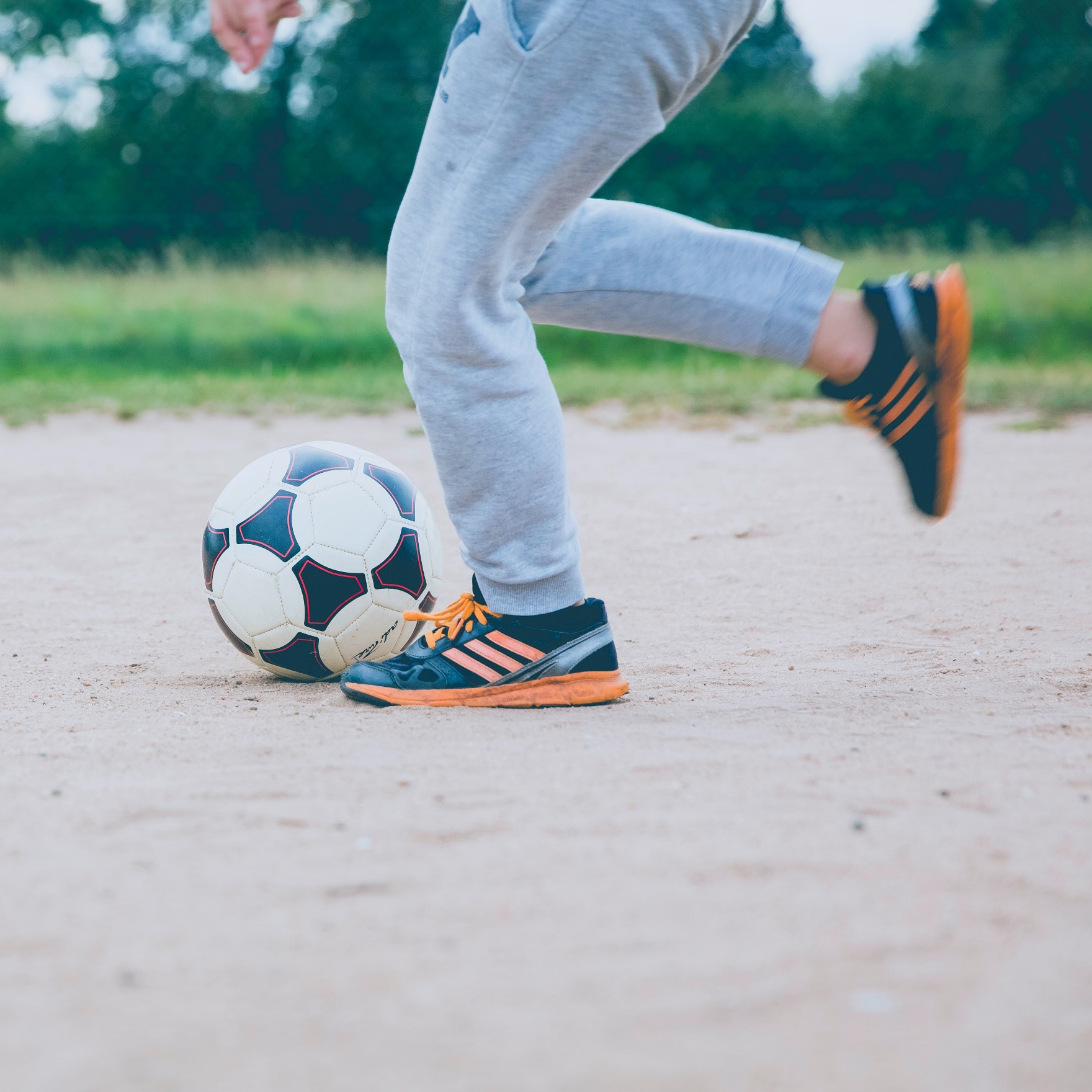 A child kicking a soccer ball. Photo by Markus Spiske on Unsplash.